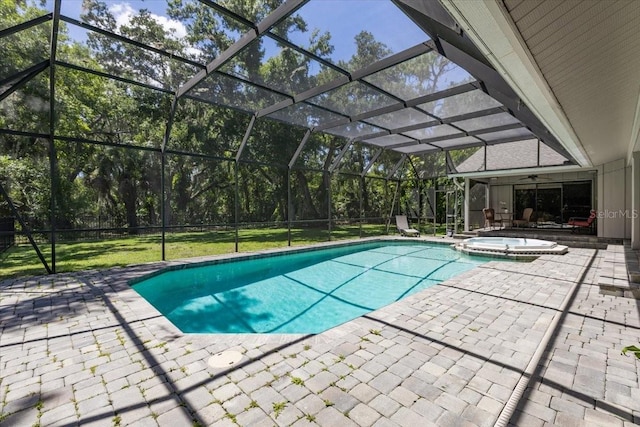 view of swimming pool featuring a lawn, ceiling fan, a lanai, an in ground hot tub, and a patio