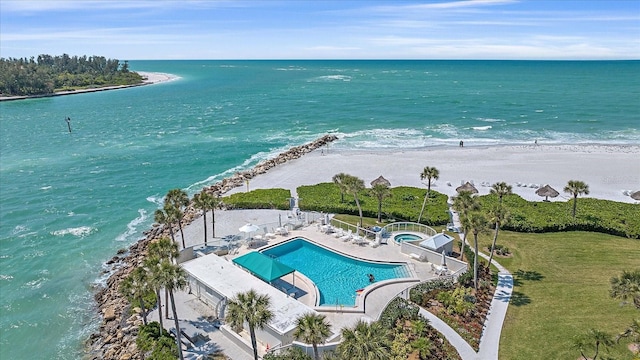 birds eye view of property featuring a water view and a beach view