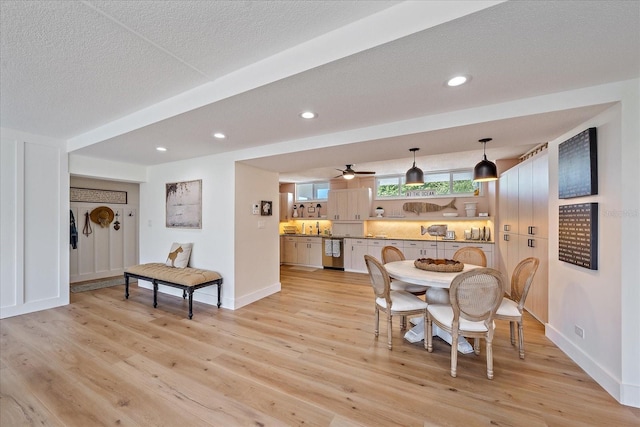 dining area featuring ceiling fan, light hardwood / wood-style flooring, and a textured ceiling