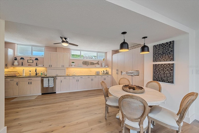 dining room featuring a textured ceiling, light hardwood / wood-style flooring, ceiling fan, and sink