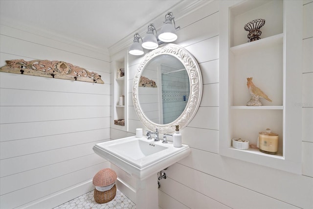 bathroom with built in shelves, crown molding, and wood walls