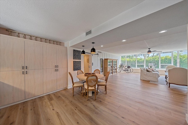 dining area featuring ceiling fan, a textured ceiling, and light wood-type flooring