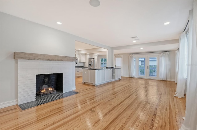 unfurnished living room featuring a fireplace and light hardwood / wood-style floors