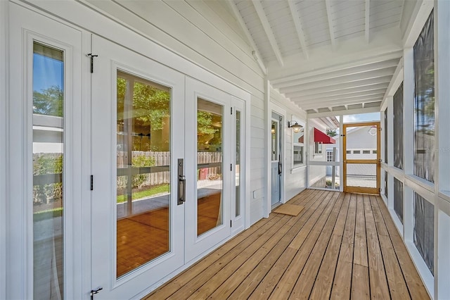 unfurnished sunroom featuring lofted ceiling with beams