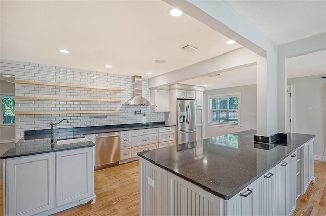 kitchen featuring white cabinets, sink, tasteful backsplash, light hardwood / wood-style floors, and stainless steel appliances