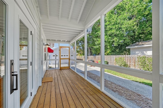 unfurnished sunroom with vaulted ceiling with beams