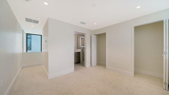 unfurnished bedroom with light carpet and ensuite bathroom