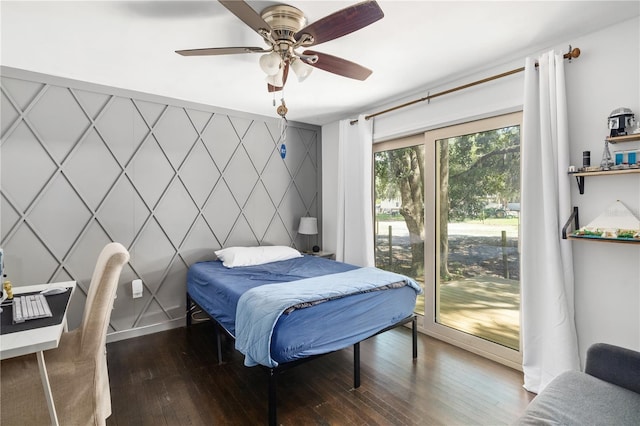 bedroom featuring access to exterior, ceiling fan, an accent wall, and hardwood / wood-style floors