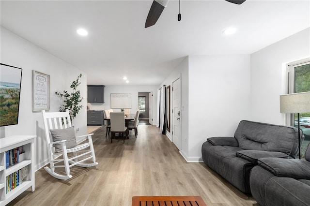 living area featuring light wood-style flooring, baseboards, a ceiling fan, and recessed lighting