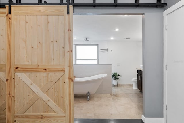 bathroom featuring recessed lighting, a soaking tub, toilet, vanity, and tile patterned flooring