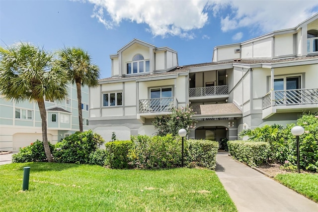 view of property featuring a front yard and stucco siding