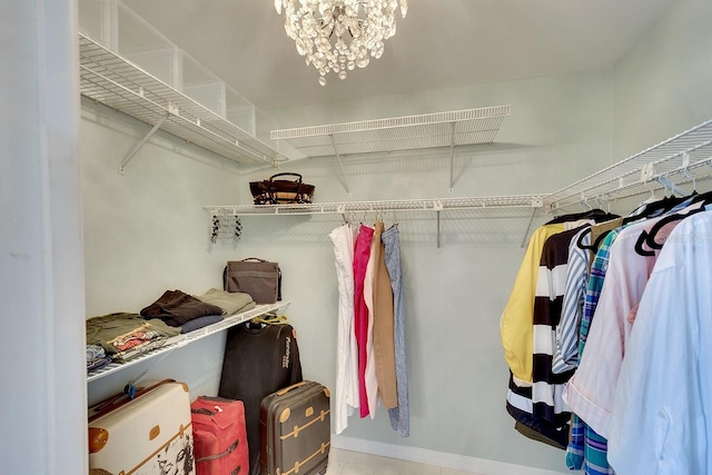 walk in closet with a notable chandelier