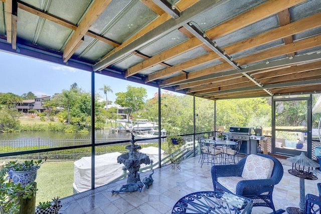 sunroom featuring a water view