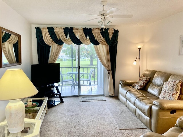 carpeted living room featuring ceiling fan and a textured ceiling