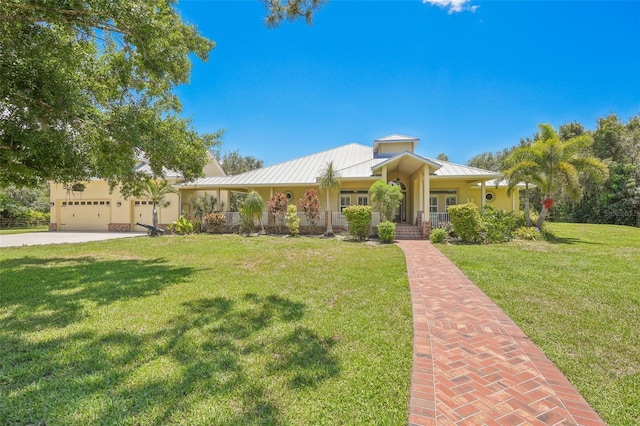 view of front of house featuring covered porch, a front lawn, and a garage