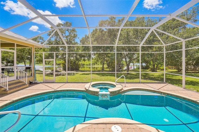 view of pool with a lawn, a lanai, an in ground hot tub, and a patio area