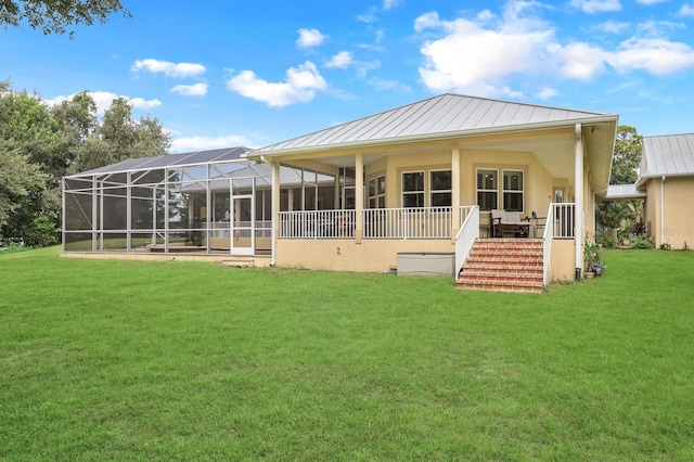 rear view of property with a lawn and glass enclosure