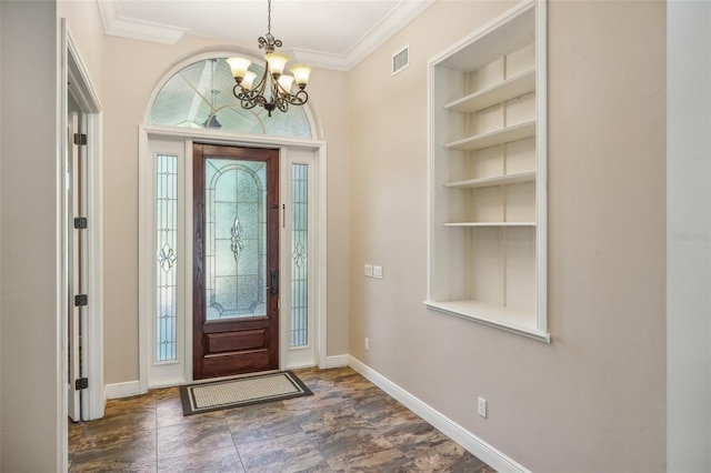 foyer featuring a chandelier and crown molding