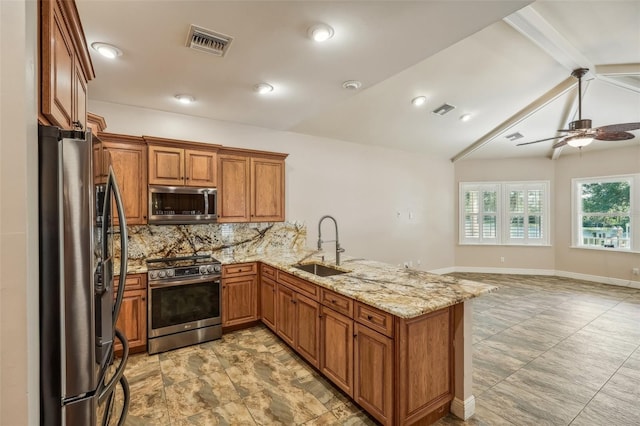 kitchen featuring sink, vaulted ceiling with beams, ceiling fan, kitchen peninsula, and appliances with stainless steel finishes