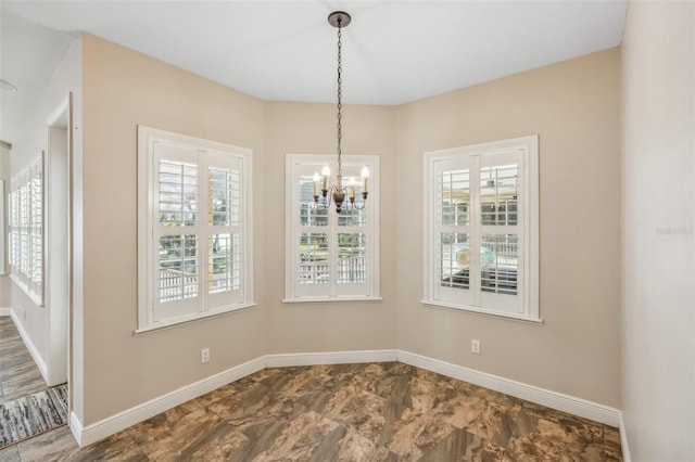 unfurnished dining area featuring a chandelier