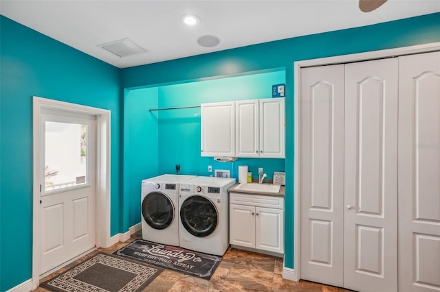 washroom with sink, cabinets, and separate washer and dryer