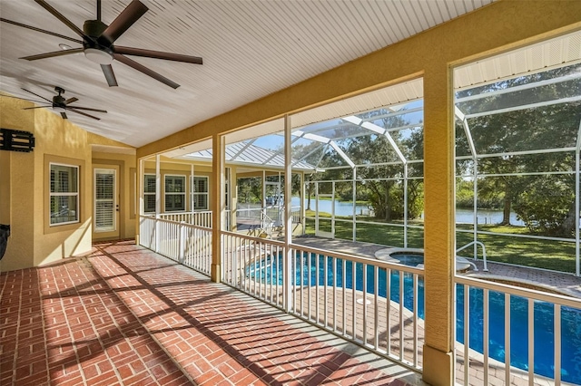 unfurnished sunroom with ceiling fan, vaulted ceiling, and a water view