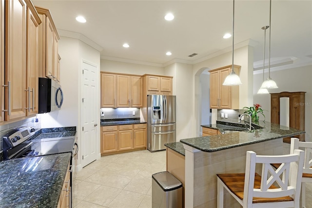 kitchen featuring a kitchen breakfast bar, sink, hanging light fixtures, decorative backsplash, and stainless steel appliances