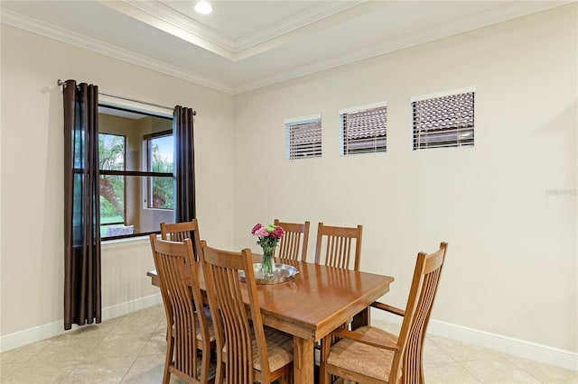 dining area featuring ornamental molding, light tile patterned floors, and a tray ceiling