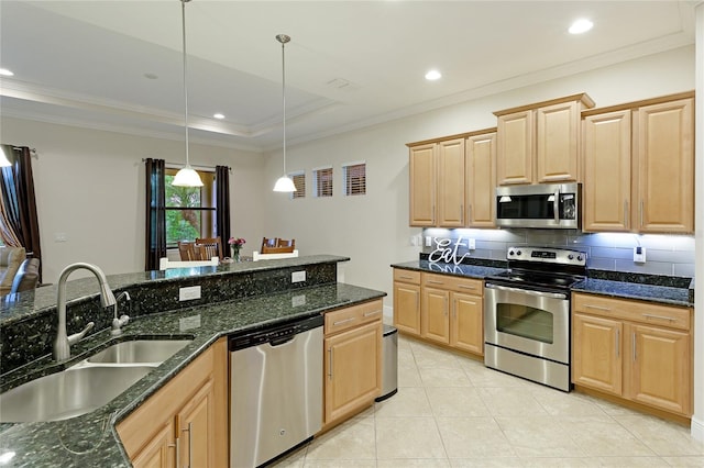 kitchen with appliances with stainless steel finishes, light brown cabinets, decorative light fixtures, and sink