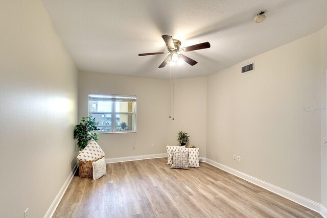 unfurnished room featuring ceiling fan, a textured ceiling, and light hardwood / wood-style floors