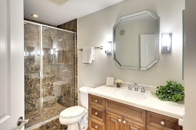 bathroom featuring toilet, vanity, and an enclosed shower