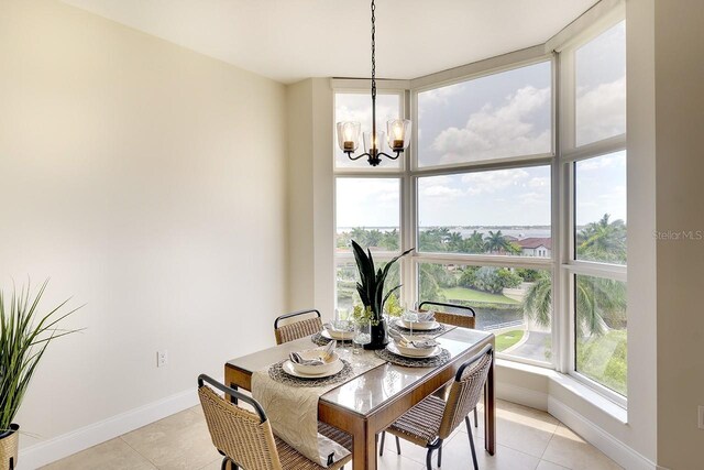 dining space with light tile patterned floors and an inviting chandelier