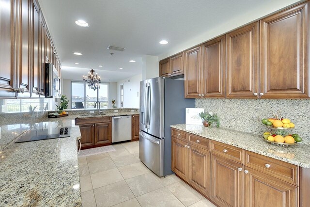 kitchen with light stone countertops, light tile patterned floors, stainless steel appliances, and tasteful backsplash