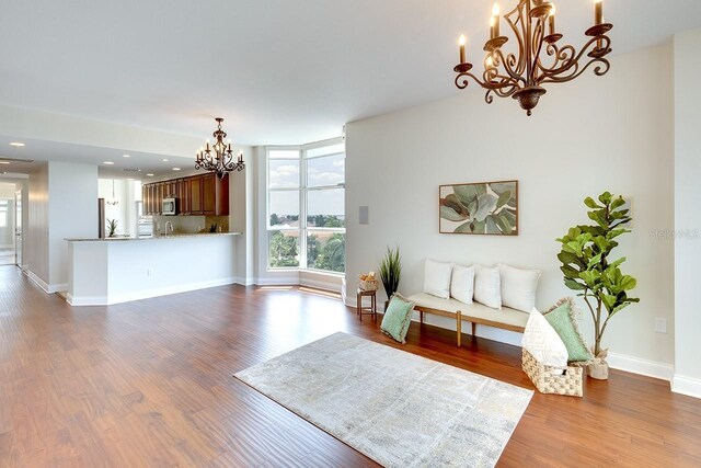 living room with wood-type flooring, expansive windows, and a chandelier