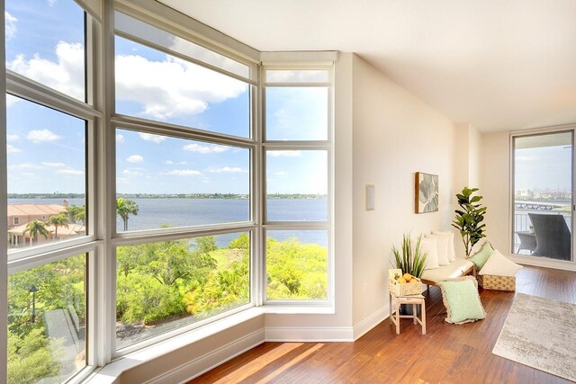 sunroom featuring a water view