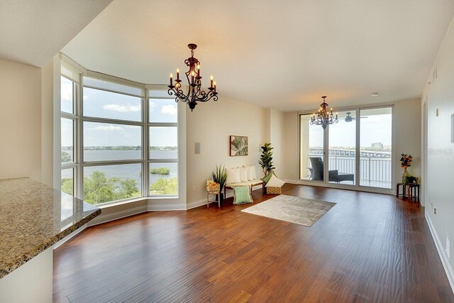 interior space featuring floor to ceiling windows, a chandelier, a water view, and dark hardwood / wood-style flooring