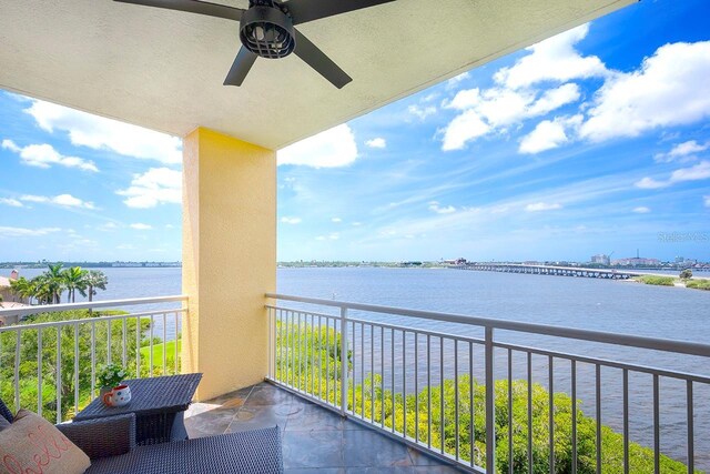 balcony with ceiling fan and a water view