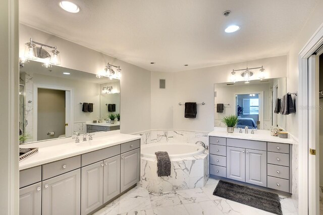 bathroom with tiled bath and vanity