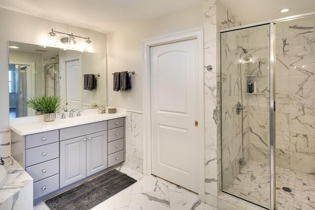 bathroom featuring a shower with shower door and vanity