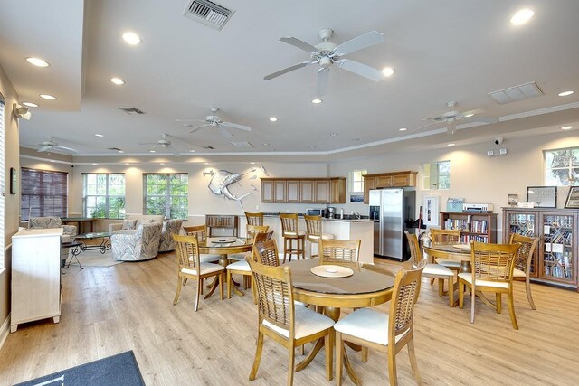 dining space with crown molding and light hardwood / wood-style floors