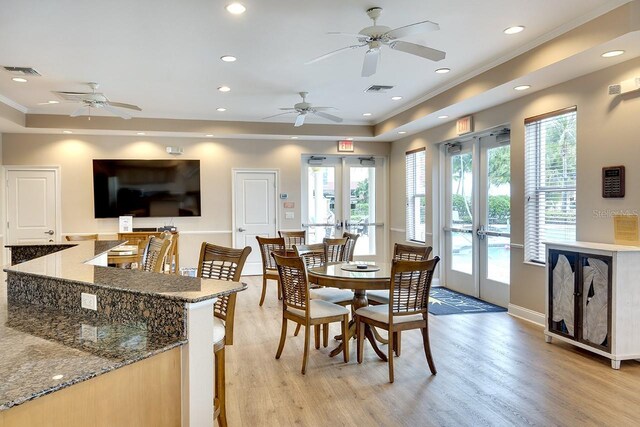 dining room featuring light hardwood / wood-style flooring, french doors, and a tray ceiling