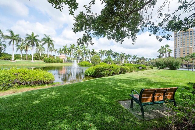 view of home's community with a water view and a yard