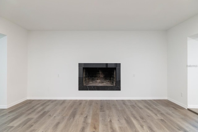 details featuring hardwood / wood-style flooring and a tile fireplace