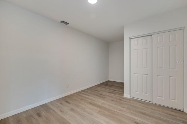 unfurnished bedroom featuring a closet and light wood-type flooring