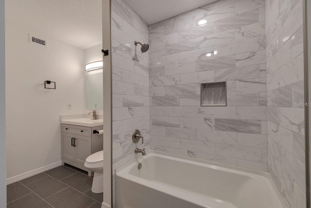 full bathroom with vanity, tiled shower / bath combo, tile patterned floors, and toilet