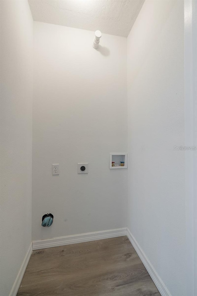 clothes washing area with wood-type flooring, hookup for an electric dryer, washer hookup, and a textured ceiling