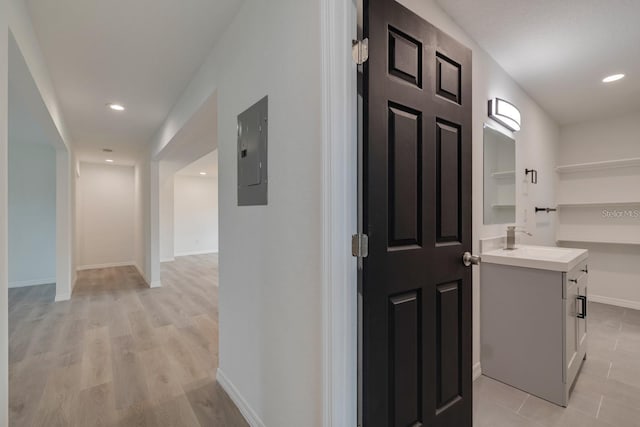 hallway with sink and light hardwood / wood-style flooring