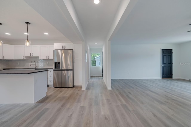 kitchen with sink, decorative light fixtures, stainless steel fridge with ice dispenser, light hardwood / wood-style flooring, and white cabinets