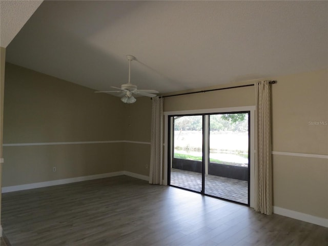 spare room with a textured ceiling, ceiling fan, wood-type flooring, and vaulted ceiling