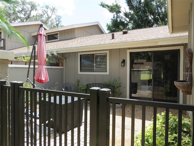 exterior space with a shingled roof and fence